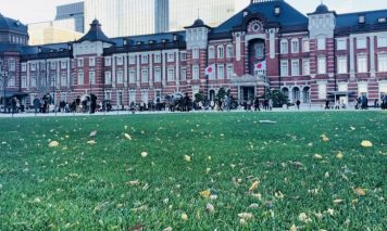 赤レンガ造りの東京駅舎と丸の内駅前広場の芝生